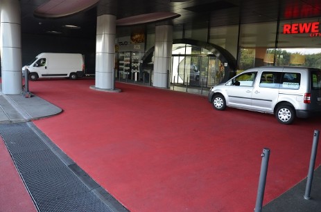 farbiger Asphalt in der Vorfahrt als roter Teppich